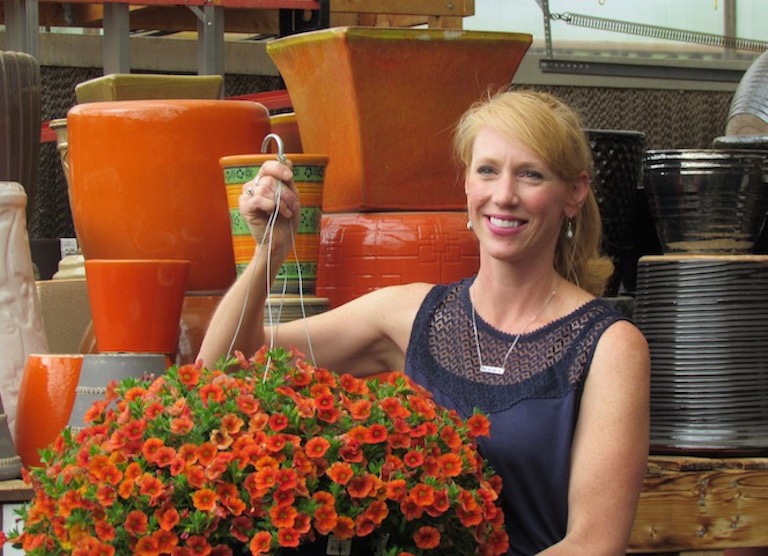 Mandy with orange pots that match her favorite hanging basket